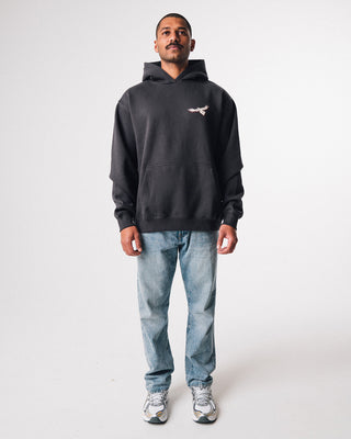 bunjil the wedged-tailed eagle hoodie in a washed out black color being worn in a front full length image displaying murrundindi eagle logo along with overall fit of the hoodie
