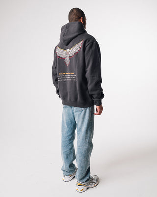 bunjil the wedged-tailed eagle hoodie in a washed out black color being worn in a side quarter image displaying fit and practically art on the back